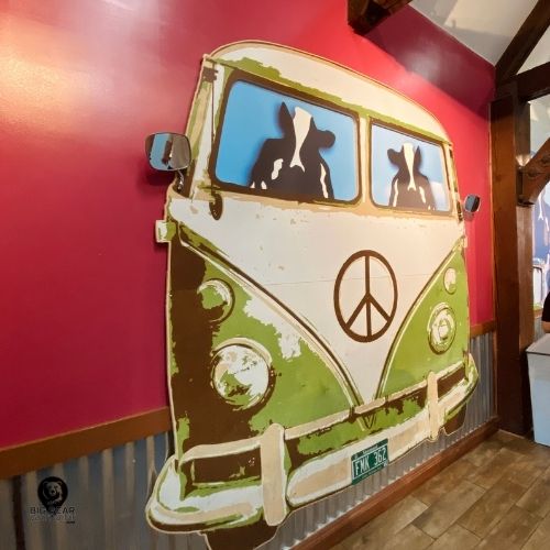 Colorful mural of a green VW bus with peace sign and cow silhouettes inside Ben and Jerry’s Big Bear ice cream shop.