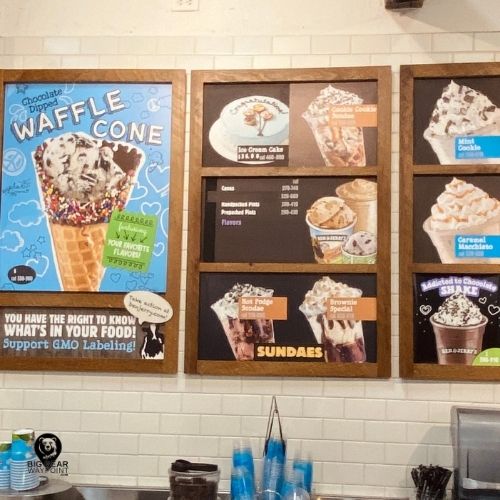 Menu board at Ben and Jerry’s Big Bear showcasing waffle cones, sundaes, milkshakes, and ice cream cakes.