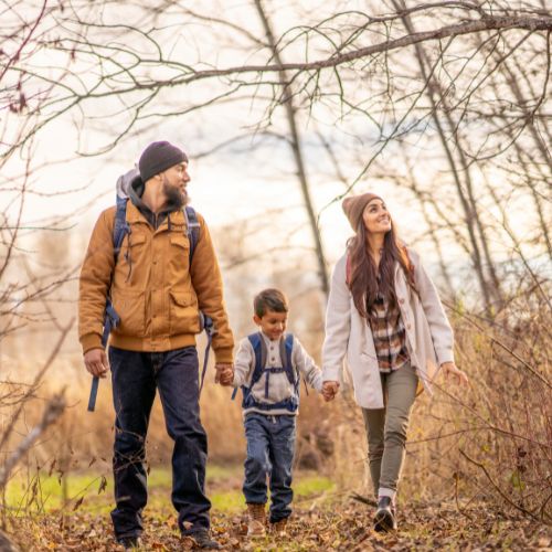 family of 3 with dad, son and mom hiking big bear in the mild winter