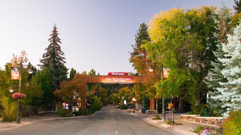 Welcome sign at The Village in Big Bear Lake, surrounded by colorful fall trees and mountain charm