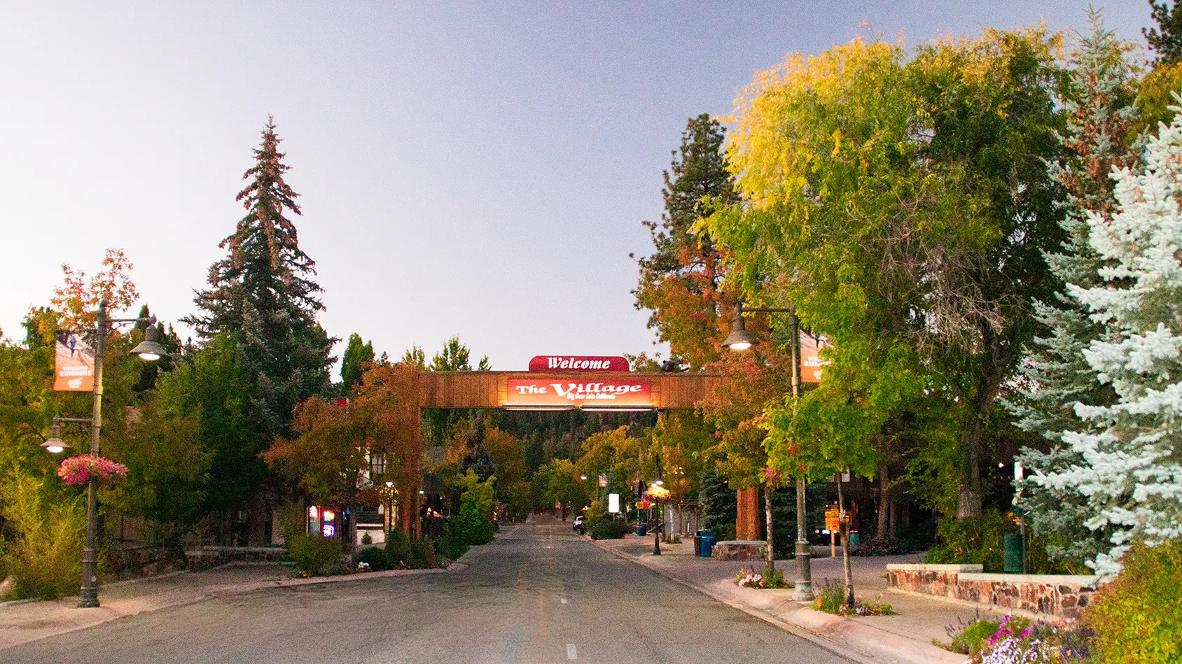Welcome sign at The Village in Big Bear Lake, surrounded by colorful fall trees and mountain charm