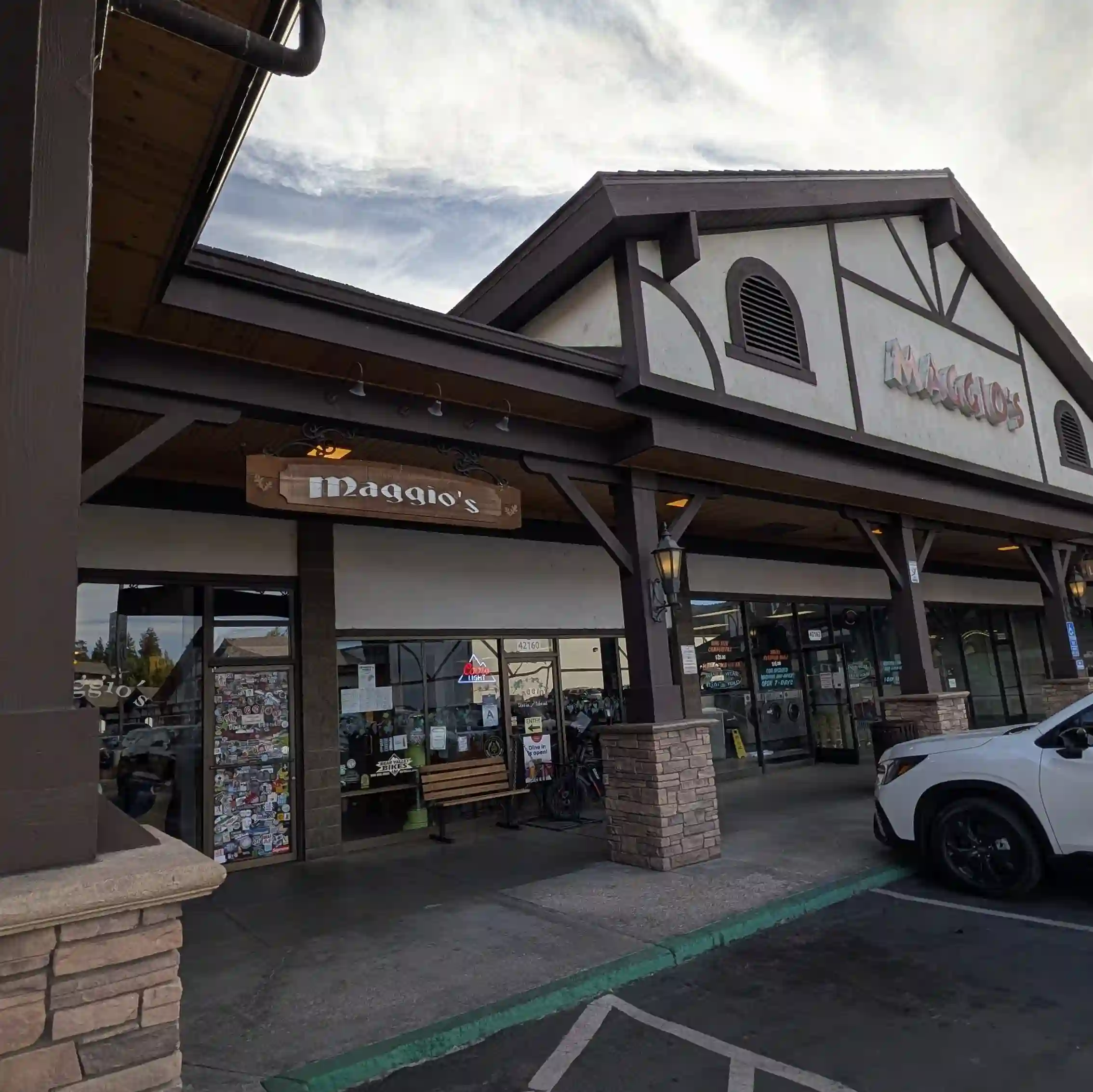 Exterior of Maggio's Pizza in Big Bear Lake, California, located in the Interlaken Shopping Center with storefront entrance and parking.