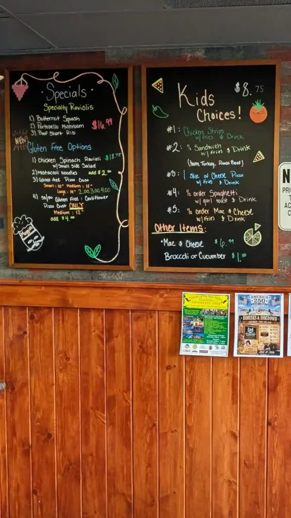Handwritten chalkboard displaying daily specials, gluten-free options, and kids menu at Maggio's Pizza in Big Bear.